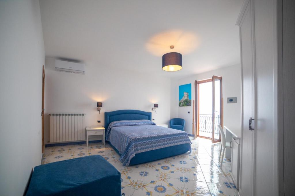 斯卡拉CASA ALBA D'ORO的一间卧室配有蓝色的床和蓝色椅子
