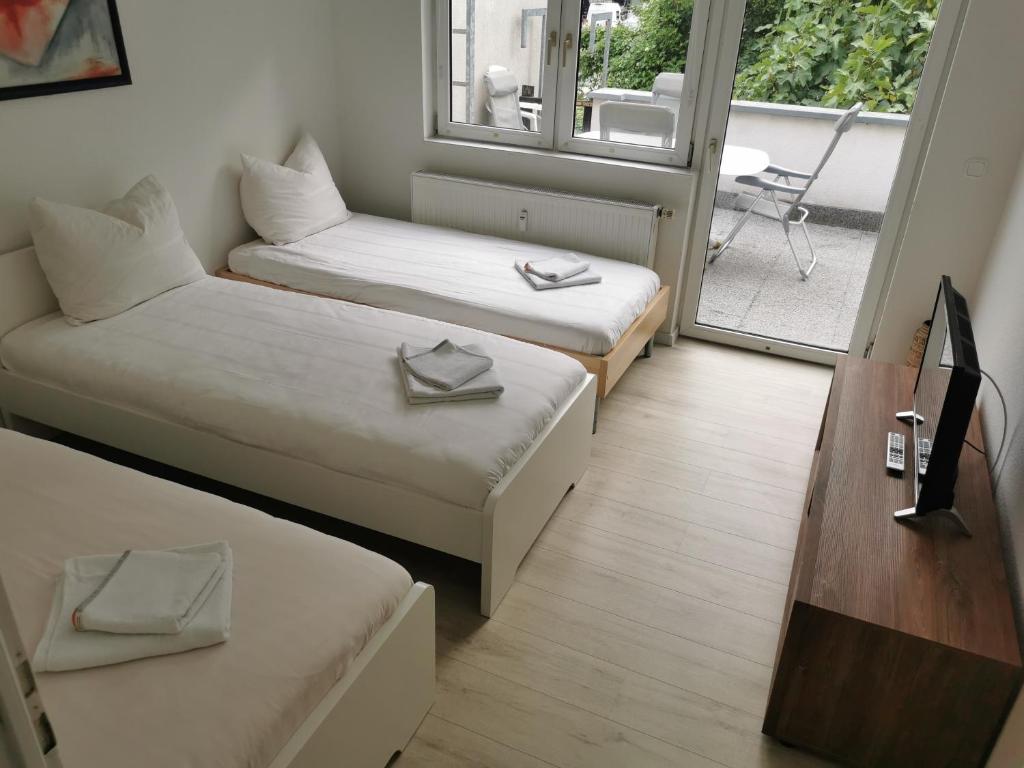 科隆Ferdimesse Apartments的小房间设有两张床和阳台
