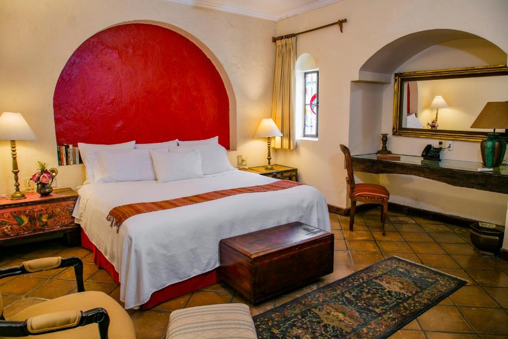 瓜达拉哈拉甘兹别墅精品酒店 的一间卧室配有一张大床和红色床头板