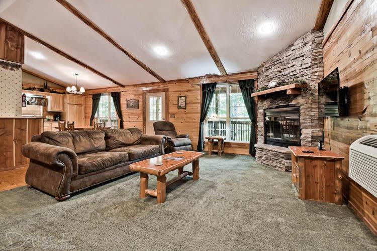 尤里卡斯普林斯Secluded Cabin Pool WiFi smart TVs Beaver lake的带沙发和石制壁炉的客厅