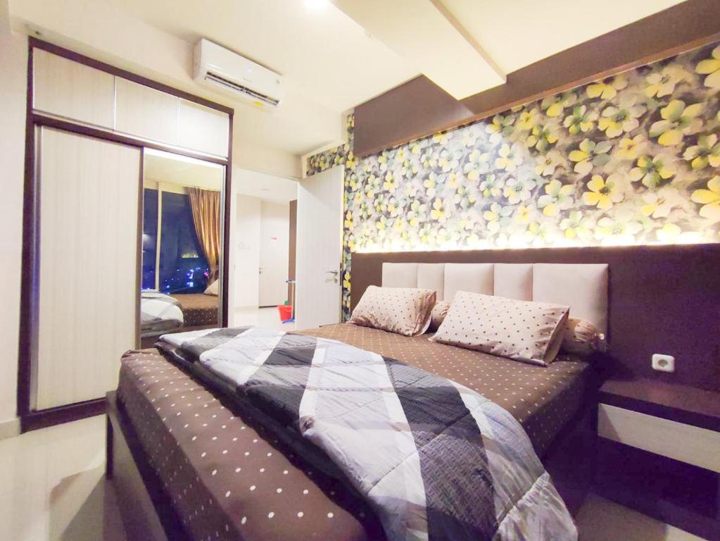 贝克西Grand Kamala Lagoon By Mitra Propertindo的一间卧室设有一张床和鲜花墙