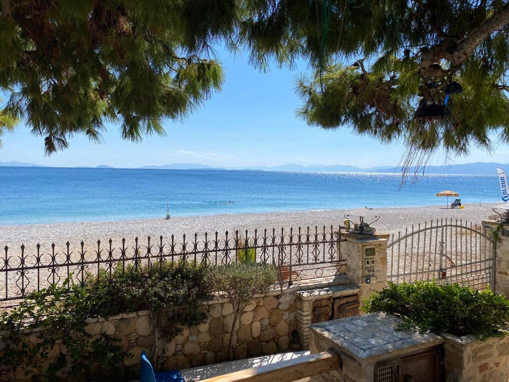 基内塔Kineta luxury House的享有带围栏的海滩和大海的景致。