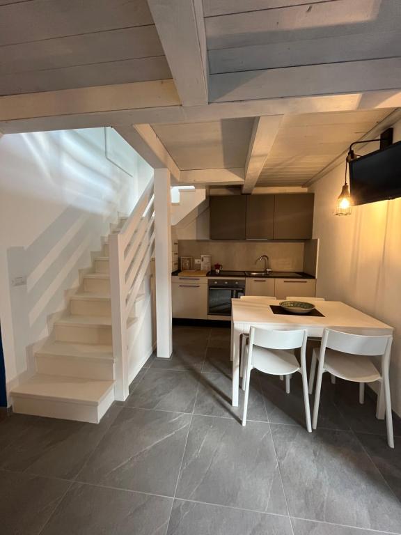 切尔维亚Chalet del mare的厨房以及带桌子和楼梯的用餐室。
