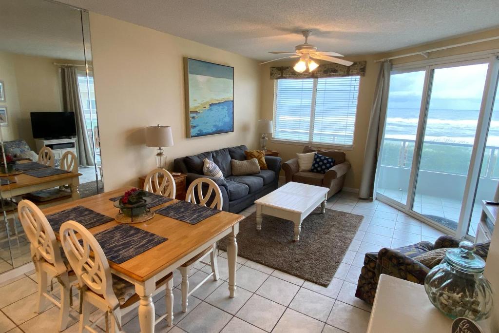 奥兰治比奇Silver Beach 205的客厅配有桌子和沙发