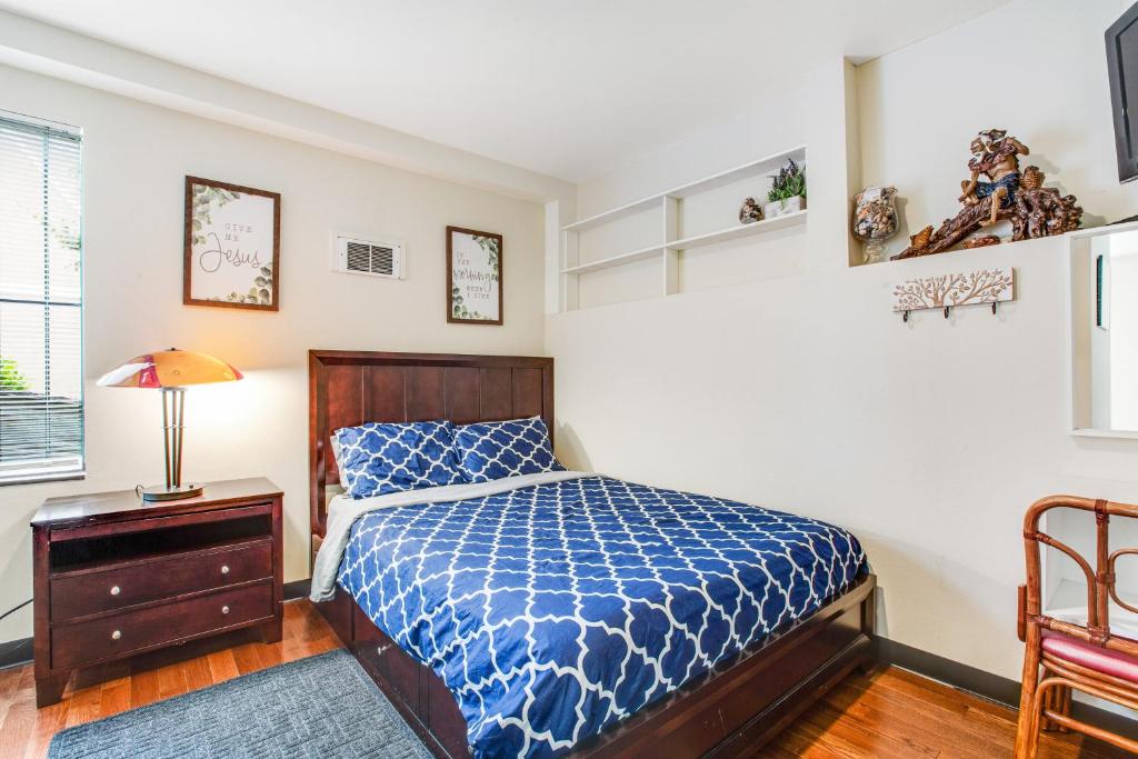 西雅图Beacon Hill Hideaway的一间卧室配有一张带蓝色棉被的床