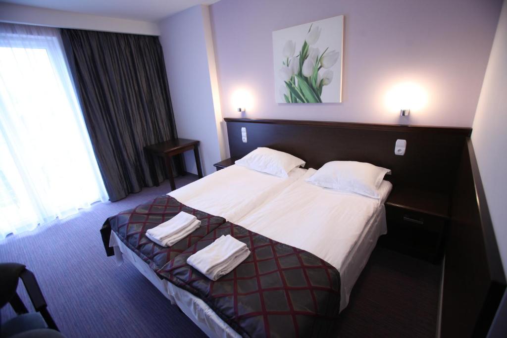 布斯克·兹德鲁伊巴杰柯伊旅馆的酒店客房配有带白色床单和枕头的床。