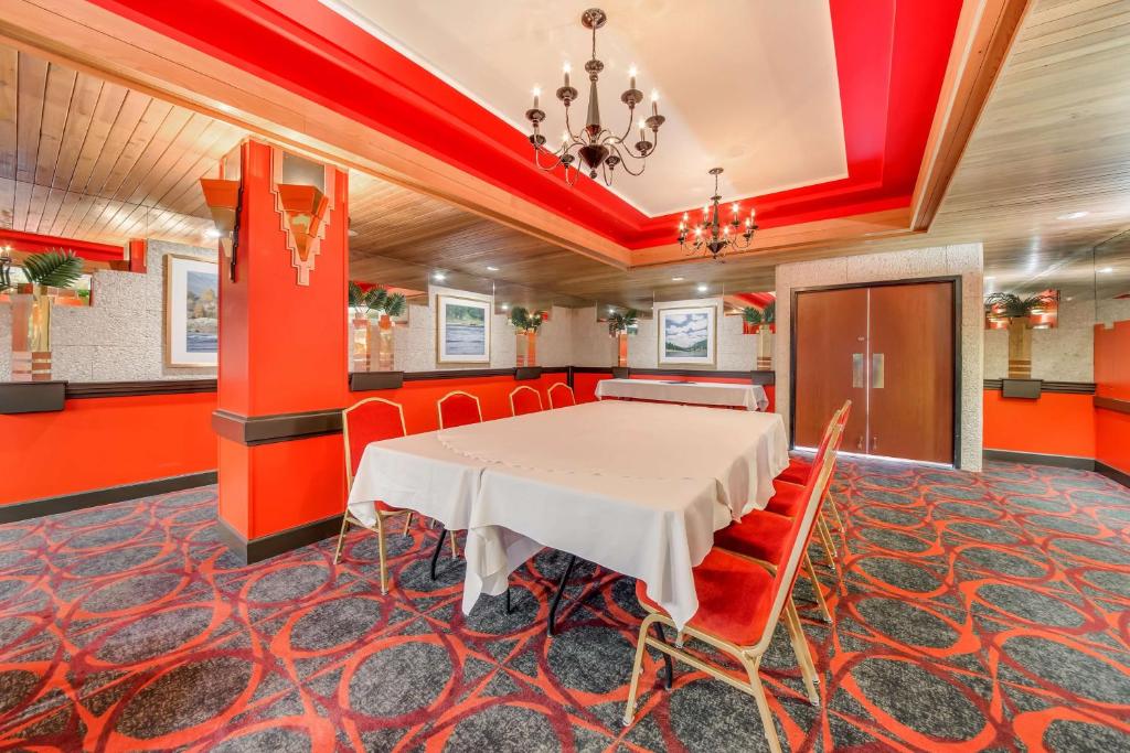 Trail哥伦比亚河贝斯特韦斯特酒店的一间设有白色桌子和红色墙壁的餐厅