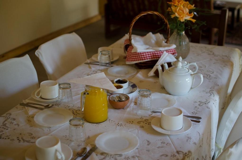 蒂诺加斯塔萨尔瓦多佐罗格里斯山林小屋的桌子,盘子,杯子,和一壶橙汁