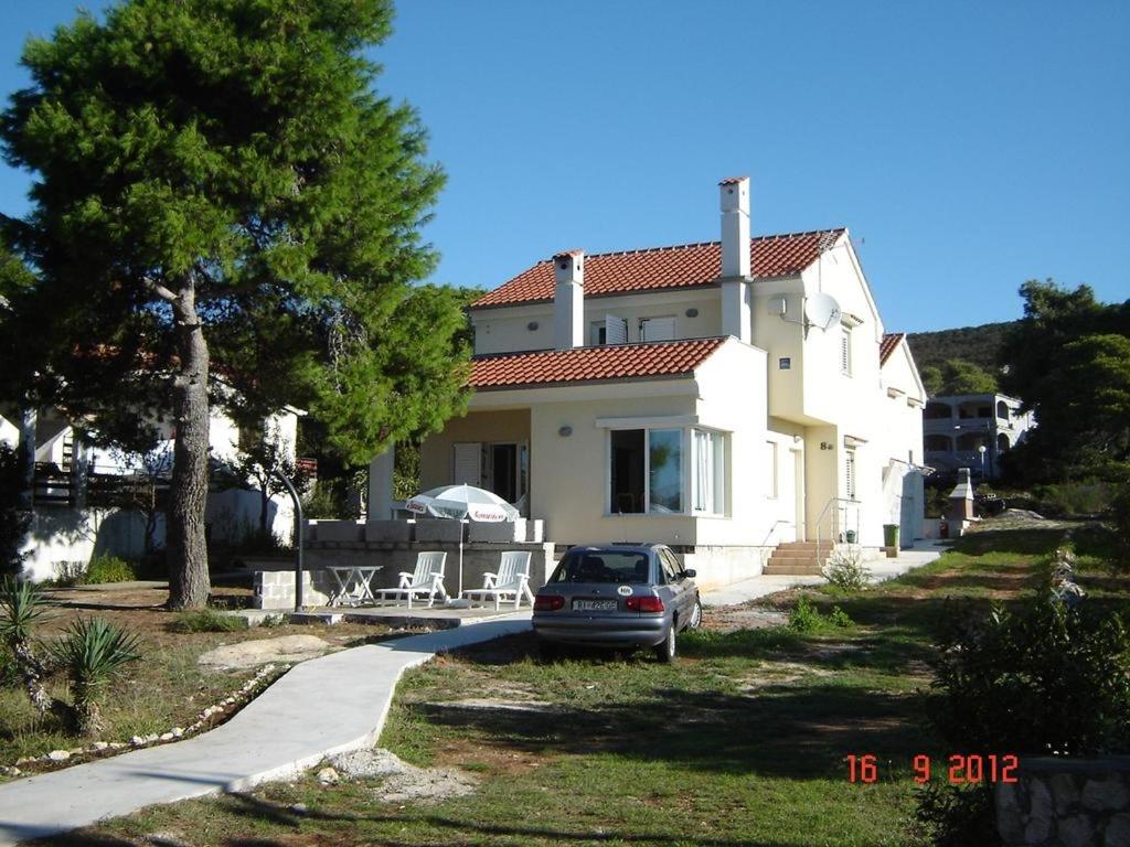 MolatApartments by the sea Brgulje, Molat - 13318的前面有停车位的房子