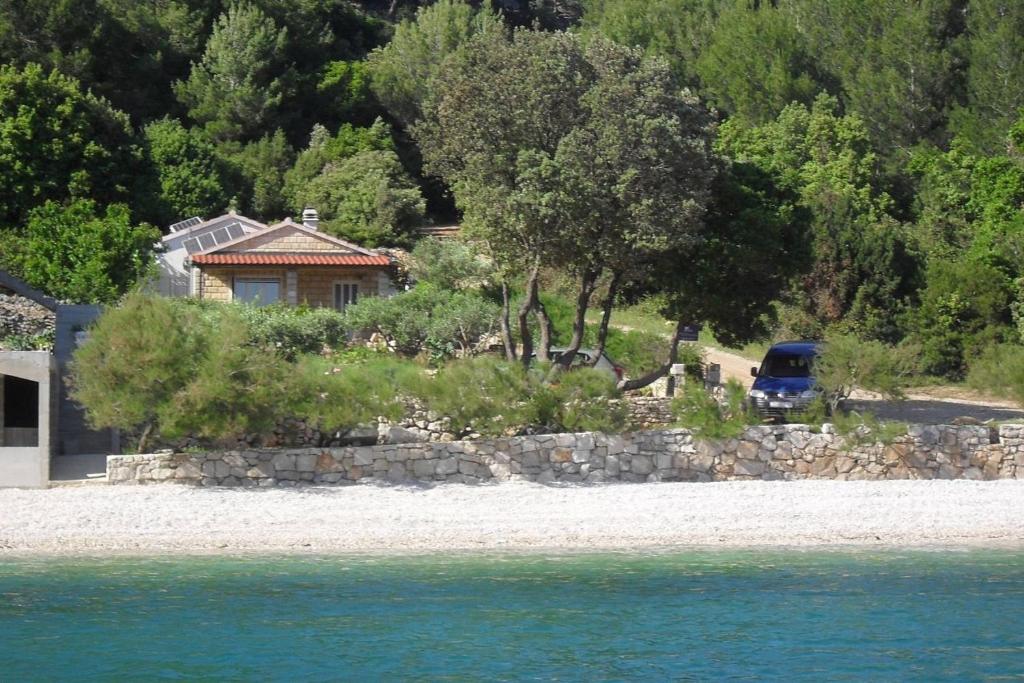 博格莫耶Secluded fisherman's cottage Cove Smokvina, Hvar - 13608的停泊在水边的一辆蓝色卡车的房子