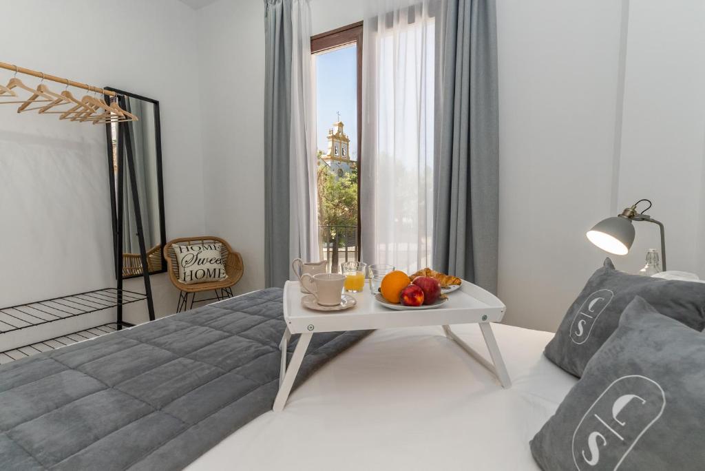 科尔多瓦Córdoba Suites Apartments的一间卧室配有一张床和一张带水果的桌子