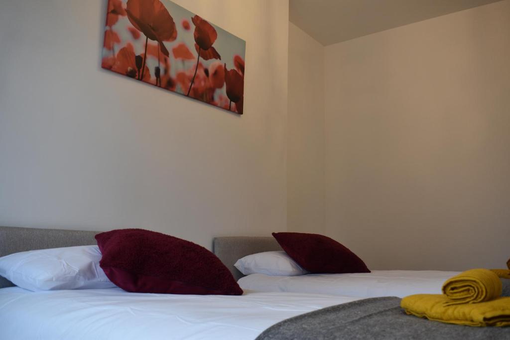 登比Camri Room的一间卧室配有两张带红白色枕头的床
