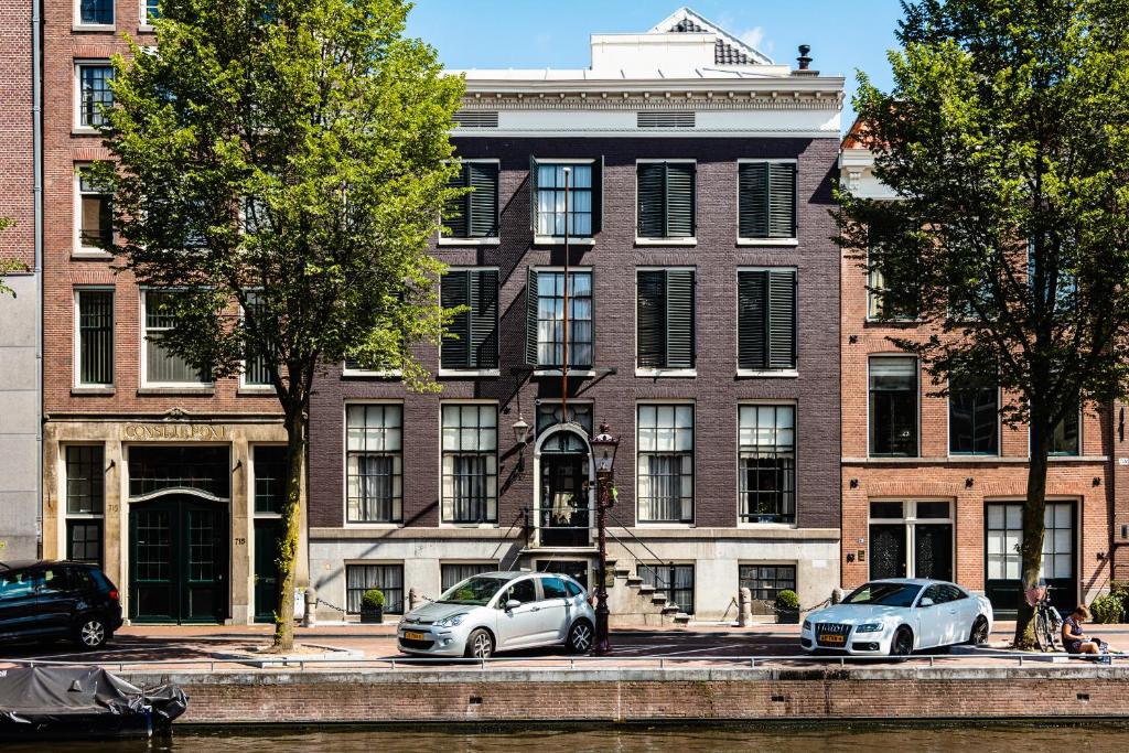 阿姆斯特丹Hotel 717的两辆汽车停在砖楼前