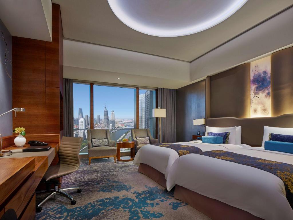 天津天津香格里拉的酒店客房配有两张床和一张书桌