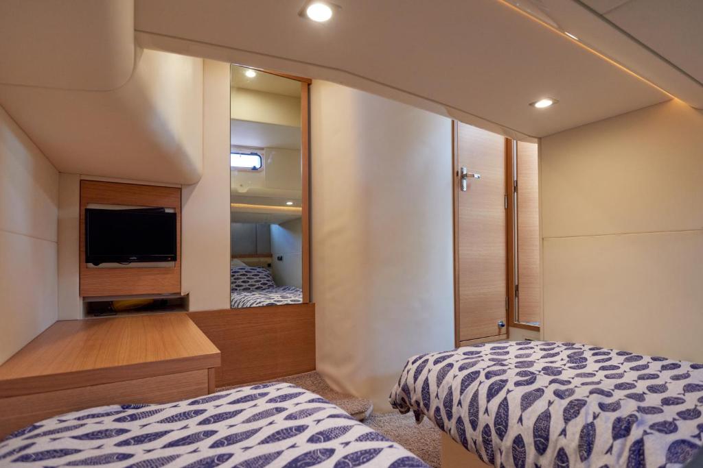 利明顿Marli II的一间卧室配有一张床、一台电视和一面镜子