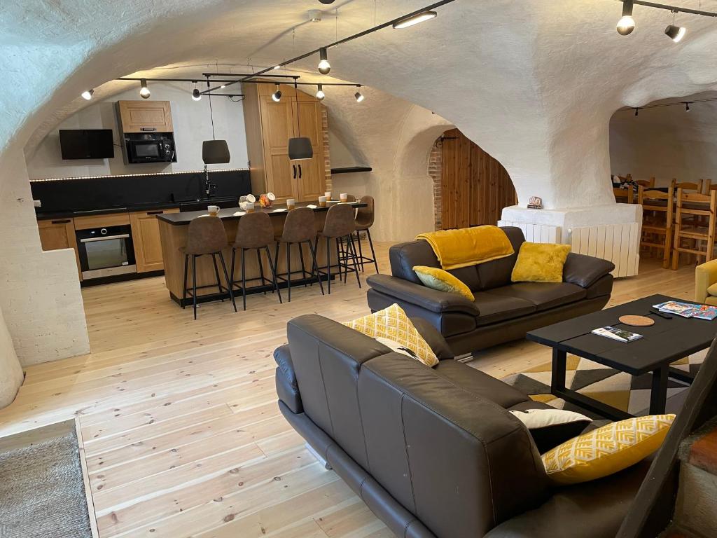 瓦尔Résidence - Gite La Mourée的带沙发和桌子的客厅以及厨房。