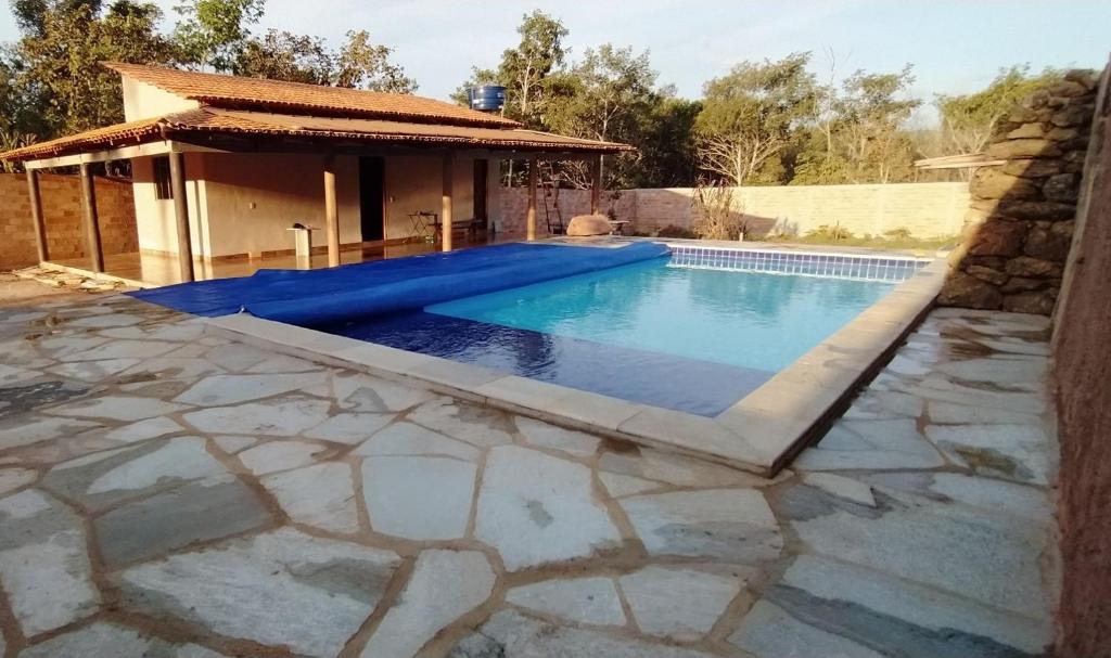 皮雷诺波利斯casa rural Bon Tempo的一座带石头庭院和房屋的游泳池