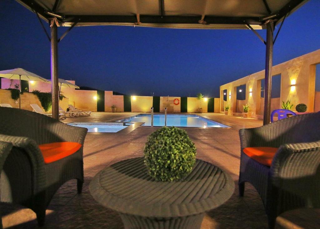杰拉什Alma Private Villa的一个带桌椅的庭院和一个游泳池