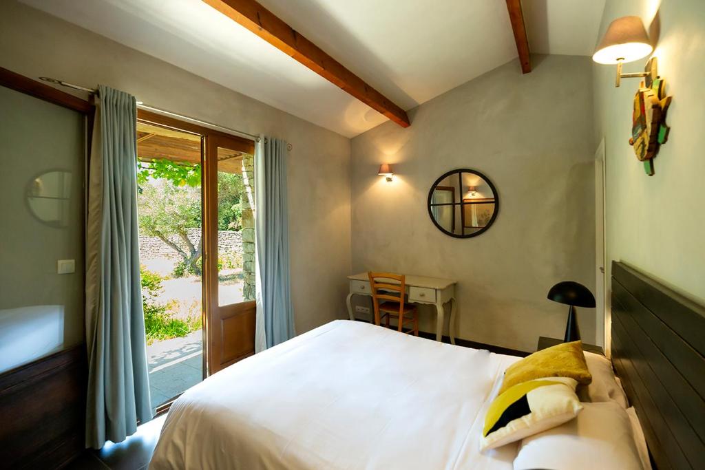 博尼法乔Les chambres SoleLuna Bonifacio的一间卧室配有一张床、一张桌子和一个窗户。