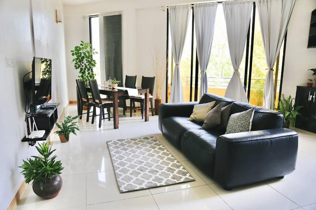 胡鲁马累BODU ASHI MALDIVES - Central 3 Bedroom Apartment的客厅配有黑色沙发和桌子