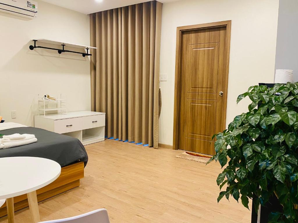 胡志明市B786 Airport Apartment的一间卧室配有床、桌子和植物