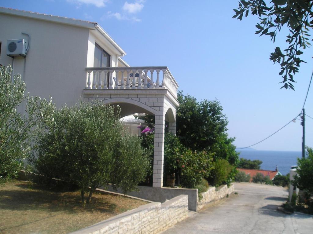 普利兹巴Apartments by the sea Prizba, Korcula - 149的白色房子的一侧设有阳台