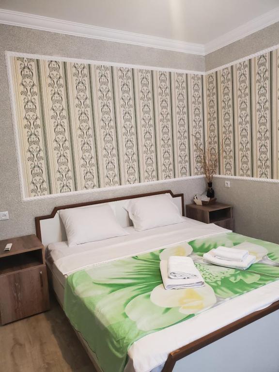 库塔伊西Beehives的一间卧室配有一张带绿毯的大床