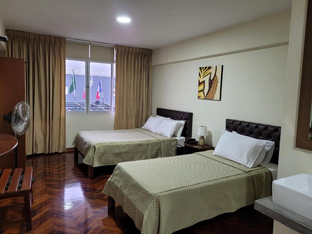 特鲁希略Hostal Solari的酒店客房设有两张床和窗户。