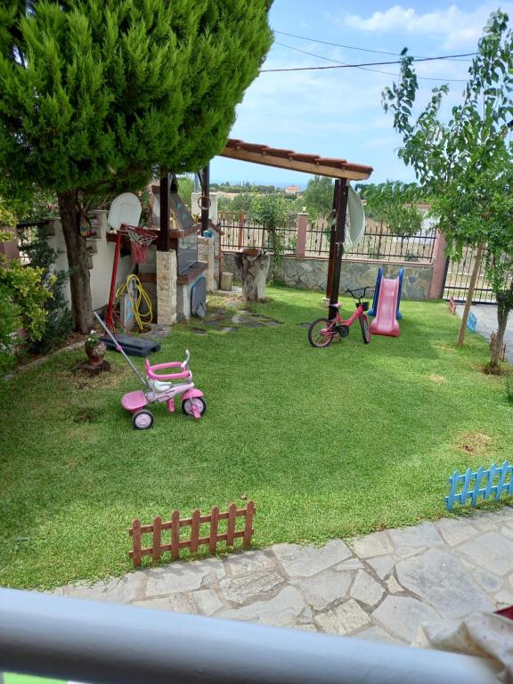 VergiaOur Country House的一个带两个粉红色儿童玩具的游乐场的院子