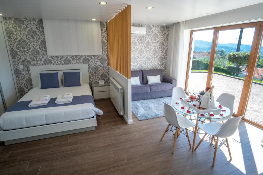阿鲁卡Villa Tavares Suítes的一间卧室配有一张床和一张桌子及椅子