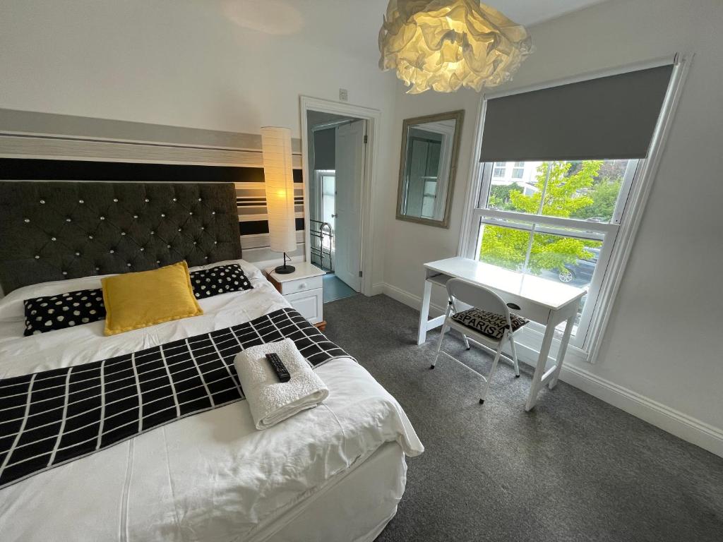 诺里奇Golden Triangle Rooms的一间卧室配有一张床、一张书桌和一个窗户。