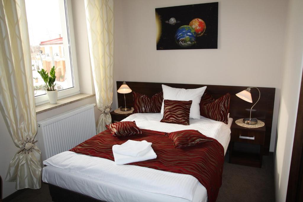 弗罗茨瓦夫弗罗茨瓦夫机场卡斯穆纳提酒店的一间卧室配有一张带红色毯子的大床