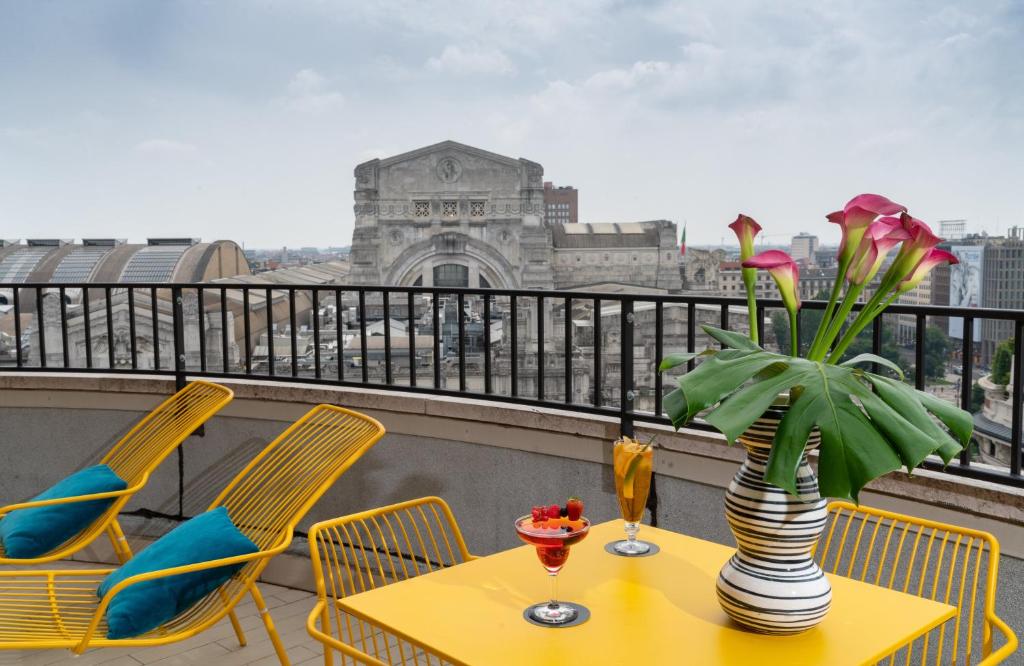 米兰NYX Hotel Milan by Leonardo Hotels的阳台上的花瓶桌子
