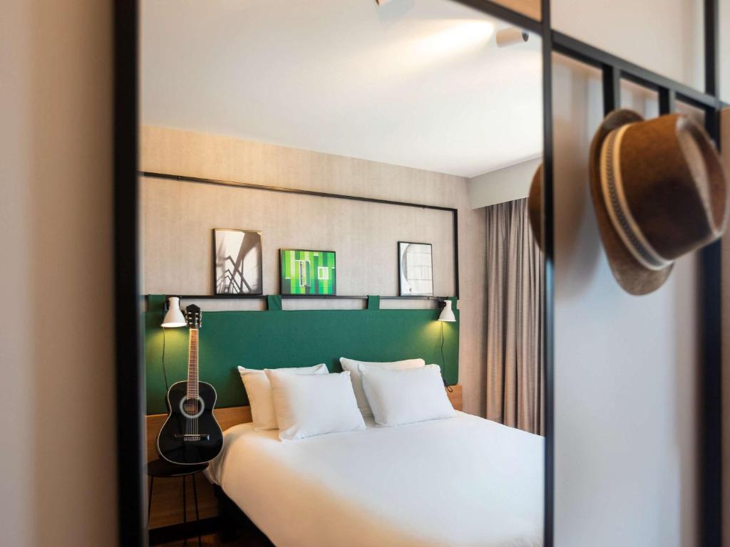斯特拉斯堡宜必思斯特拉斯堡中心乐斯哈勒斯酒店的酒店客房,配有一张带吉他的床