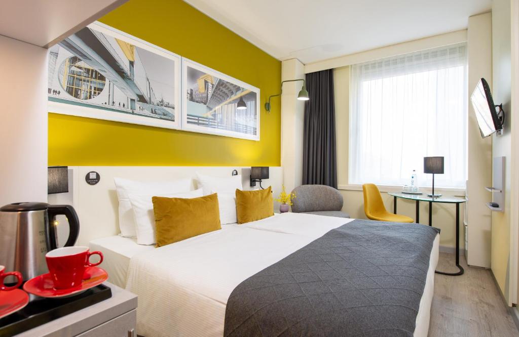 柏林柏林米特莱昂纳多酒店的酒店客房,设有床和黄色的墙壁