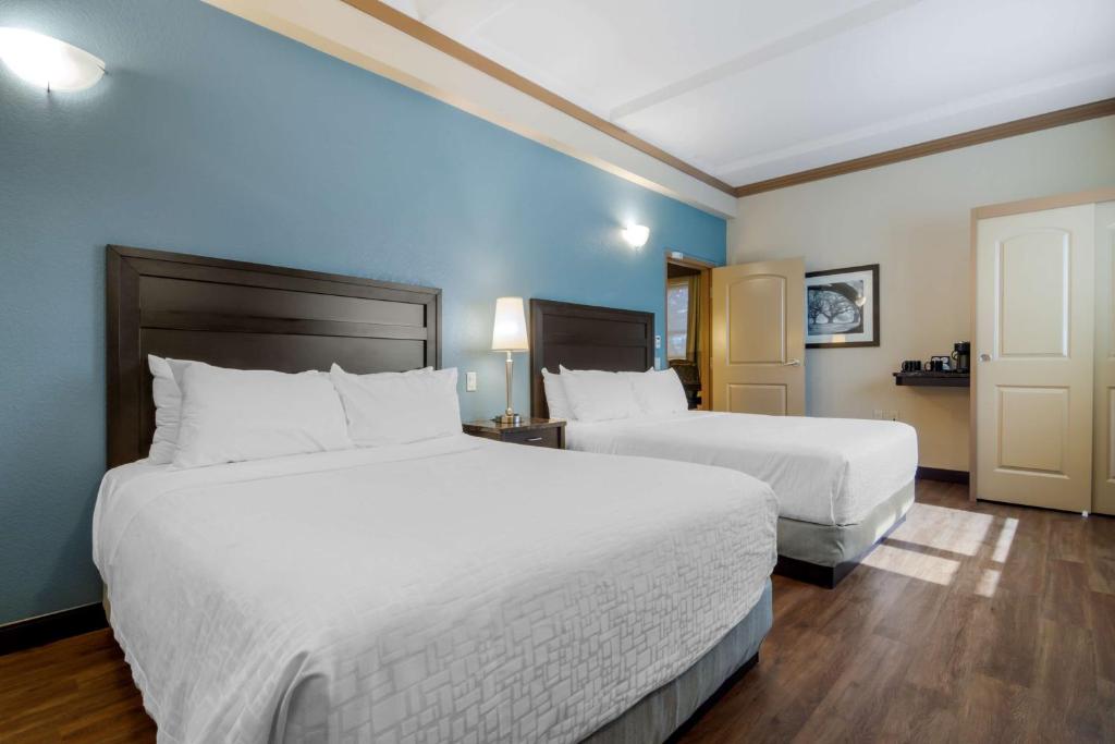 坎卢普斯坎卢普斯加酒店的两张位于酒店客房的床,拥有蓝色的墙壁