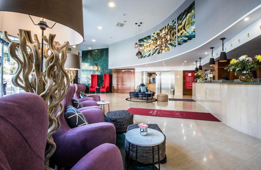 巴塞罗那巴塞罗那格兰大道莱昂纳多酒店的大堂,配有紫色椅子和桌子