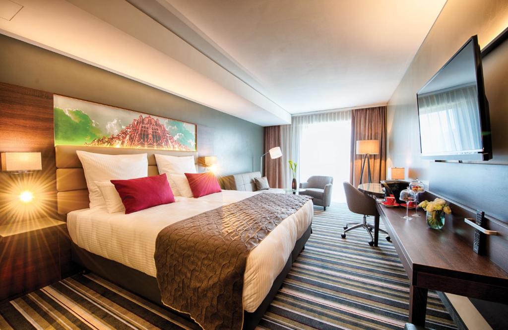 乌尔姆乌尔姆莱昂纳多皇家酒店的酒店客房设有一张大床和一张书桌。