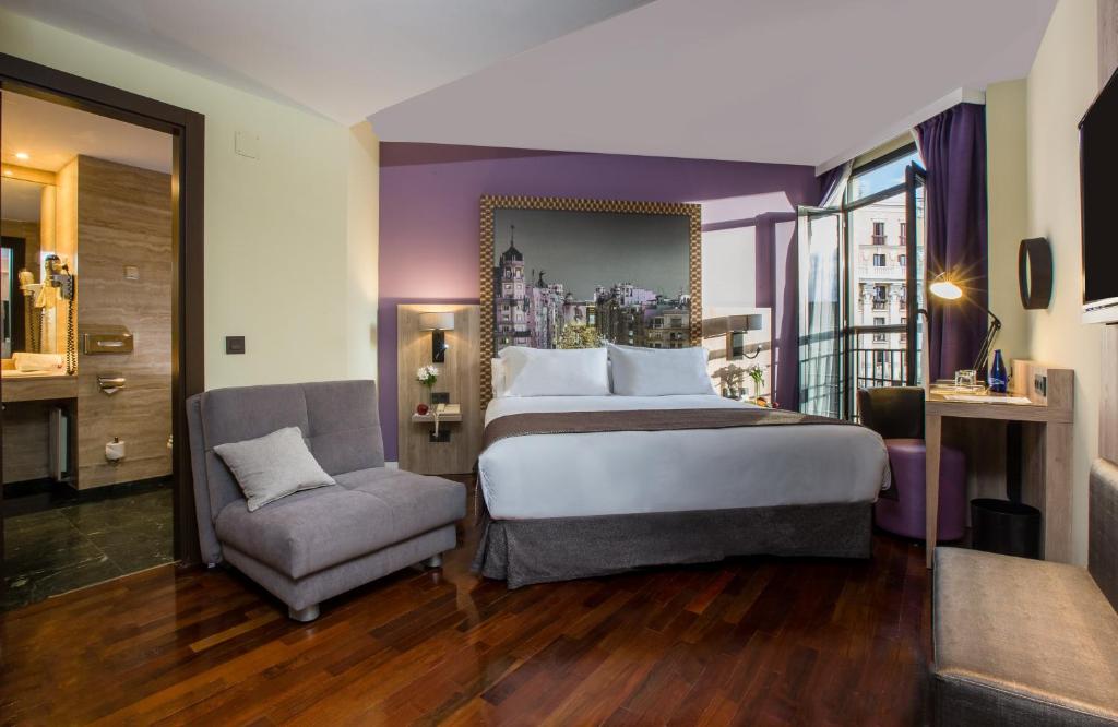 马德里马德里市中心莱昂纳多酒店的酒店客房带一张大床和一把椅子