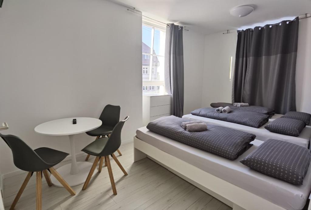 巴登-巴登Engel Apartments Baden-Baden的一间卧室配有两张床和一张桌子及椅子