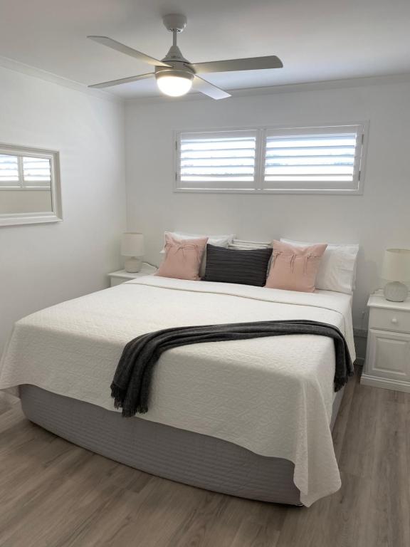 彩虹海滩Rainbow Beach Dream Newly Renovated Stylish One Bedroom Apartment的白色卧室配有带粉红色枕头的大床