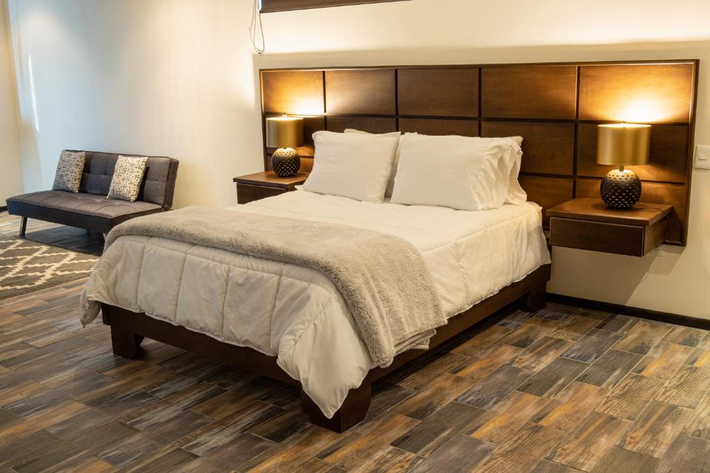 瓜达鲁佩镇Estancias Sierravita的一间卧室配有一张大床和一把椅子