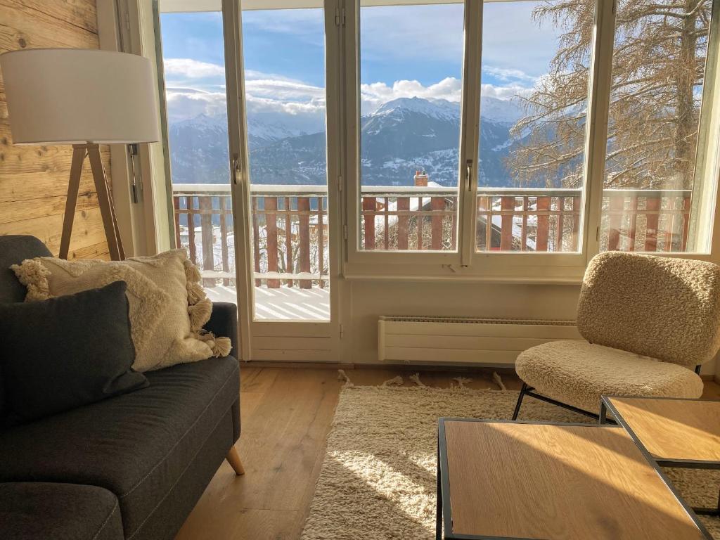 克莱恩 蒙塔纳Apartment Del Sol Elysée 4 Crans Montana Switzerland的带沙发、椅子和窗户的客厅