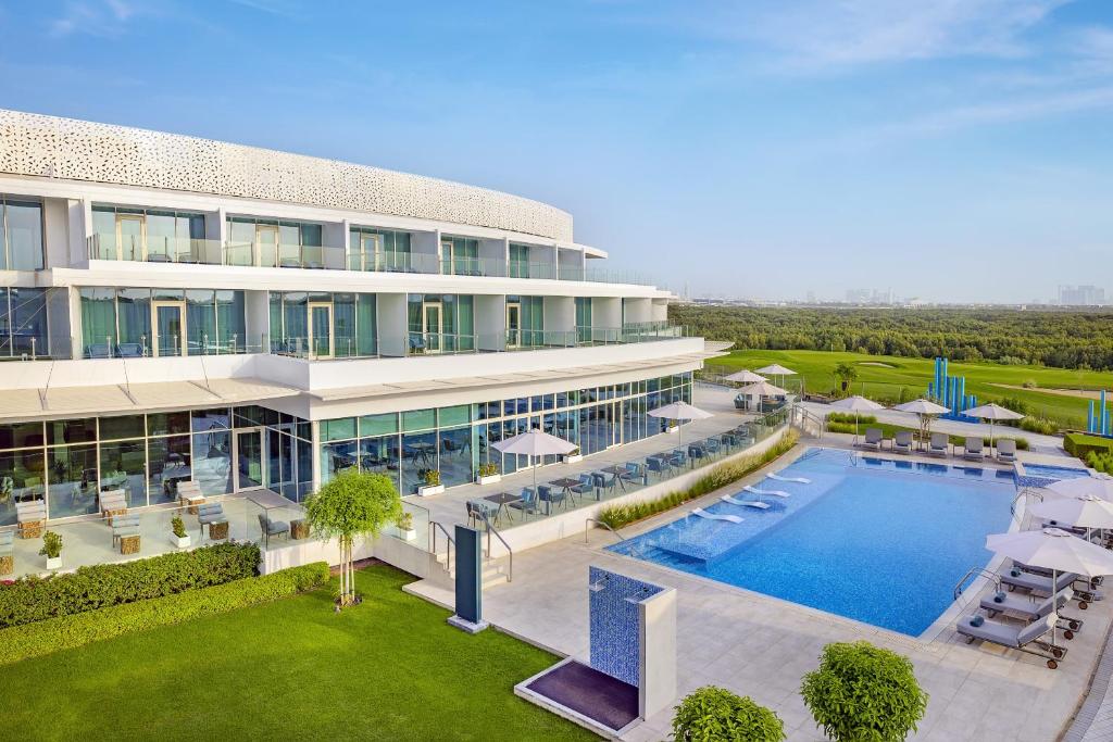 阿吉曼Zoya Health & Wellbeing Resort的享有带游泳池的建筑的空中景致