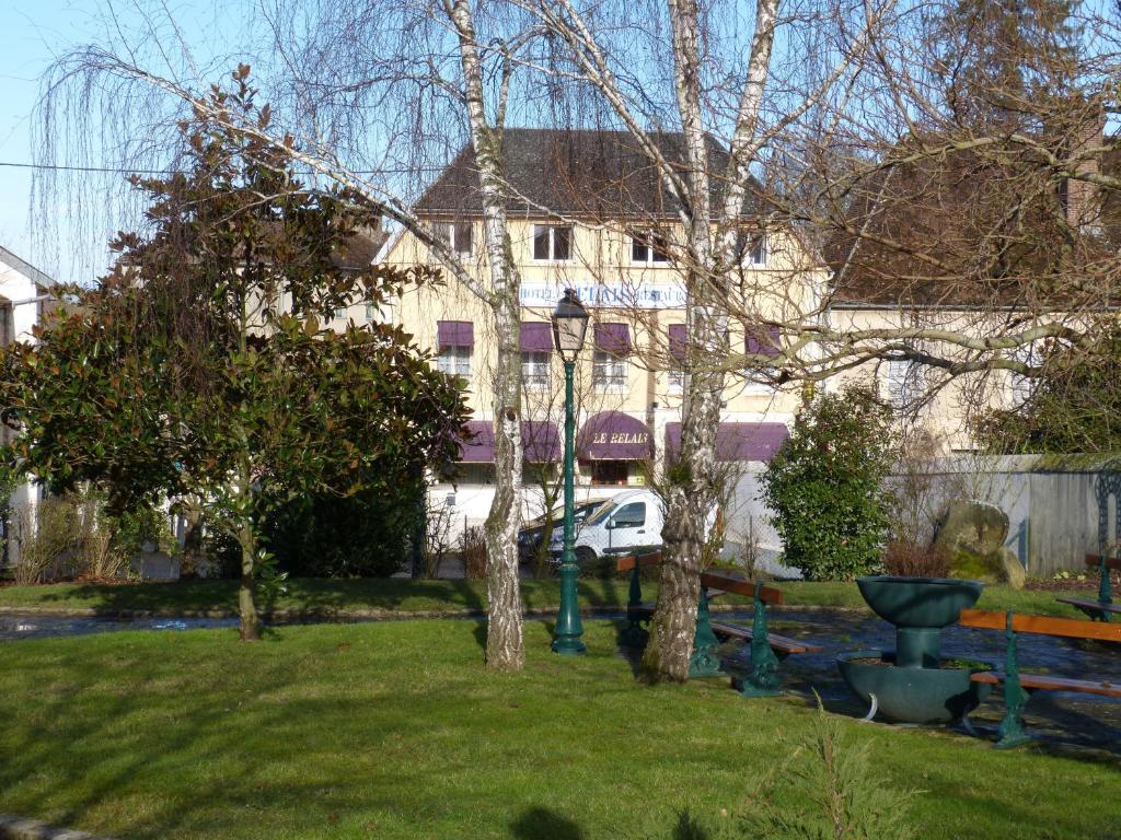 考特尼Hôtel Restaurant "Le Relais"的一座有树木的院子和一座建筑