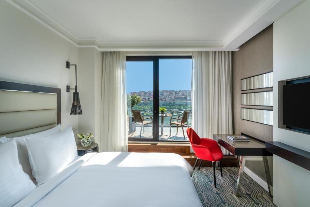 伊斯坦布尔莫凡彼伊斯坦布尔金角酒店的配有一张床、一张书桌和一扇窗户的酒店客房