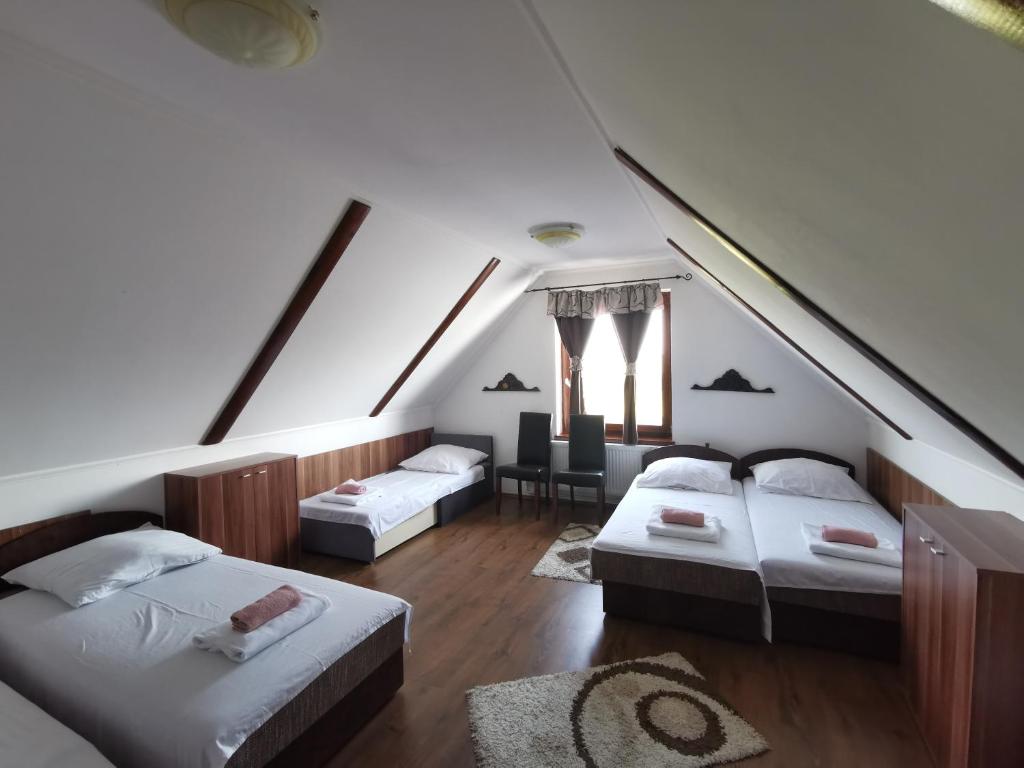 EdelényMerlot Borhotel és Látványpince的阁楼间设有两张床和一张桌子