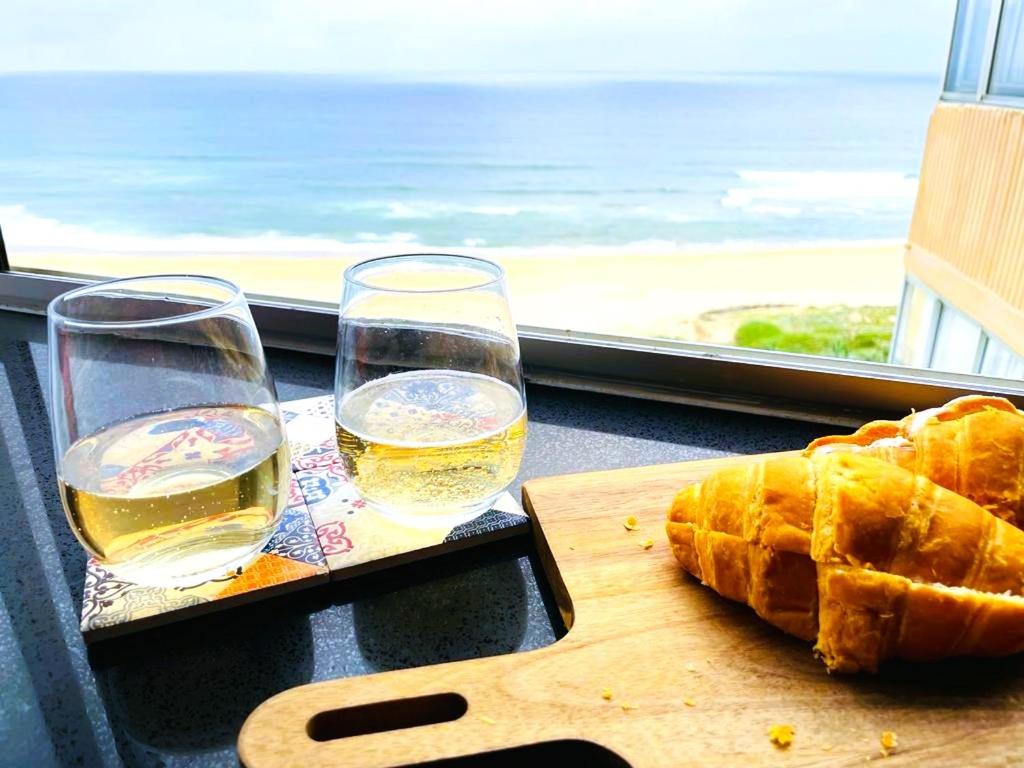 KingsboroughMai Paradise的一张桌子,上面有两杯,还有一块带面包的切板