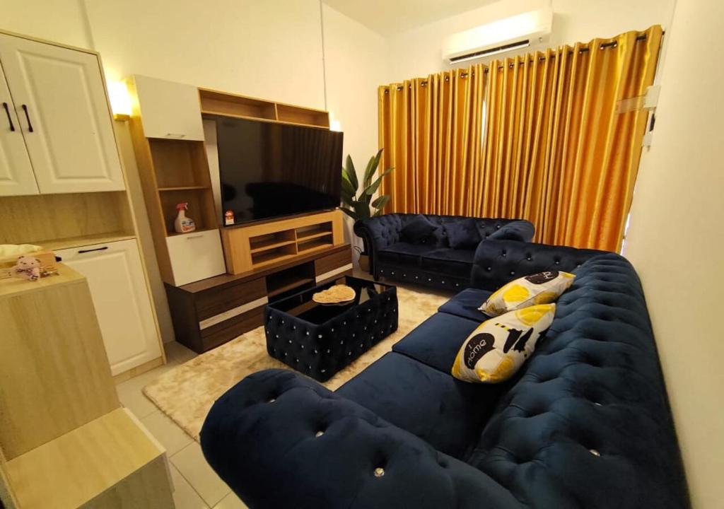 甘文丁HOMESTAY SYAABAN Kamunting Taiping Batu Kurau Ulu Sepetang的客厅配有蓝色的沙发和电视