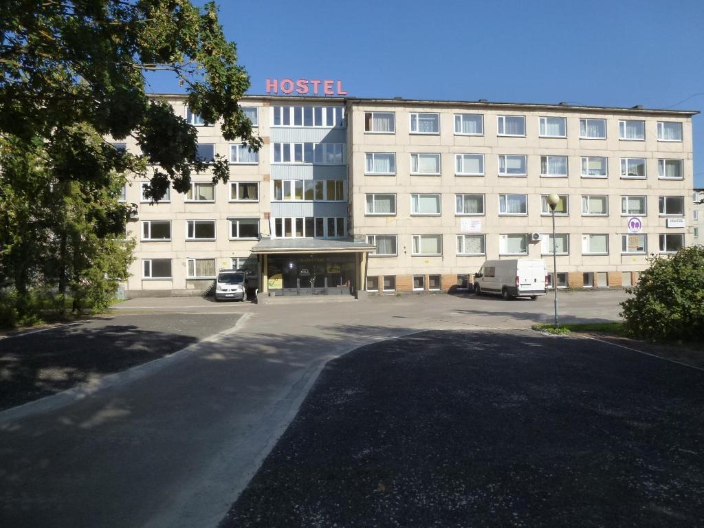 约赫维Hostel Nele的一座大型建筑,前面设有停车场